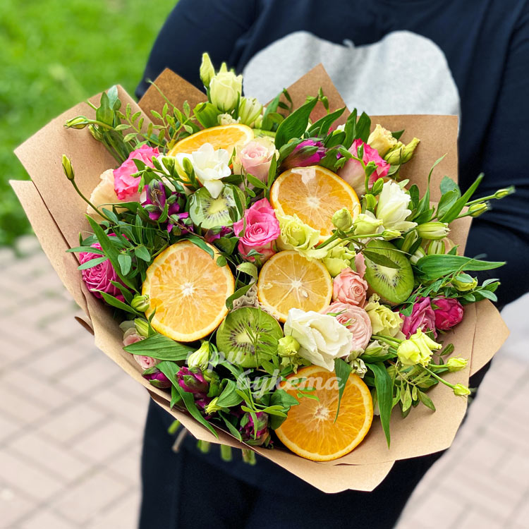 Букет из цветов и фруктов в крафте (в руках флориста)